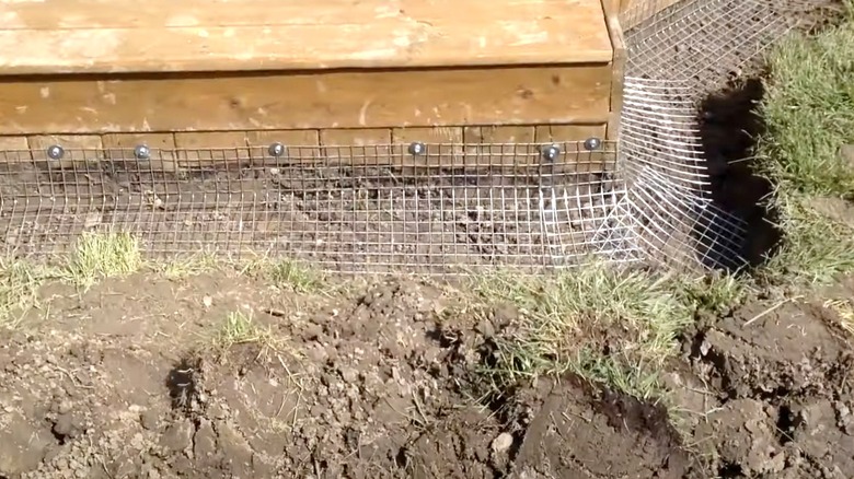 Heavy-duty mesh is installed as a deterrent along the perimeter of a wooden deck