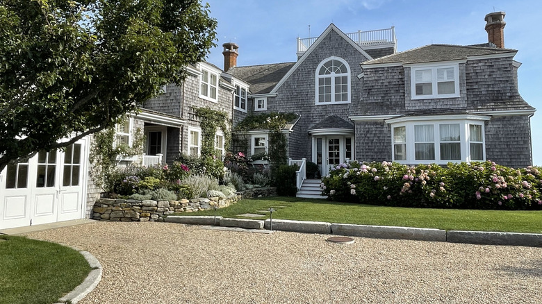 A gravel driveway near a house with concrete edging