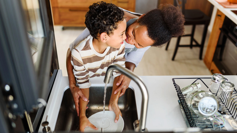 woman and boy washing plate