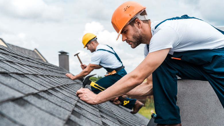 roofers working on roof of house