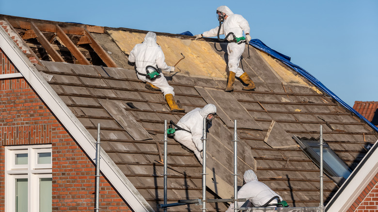 men working on roof of house