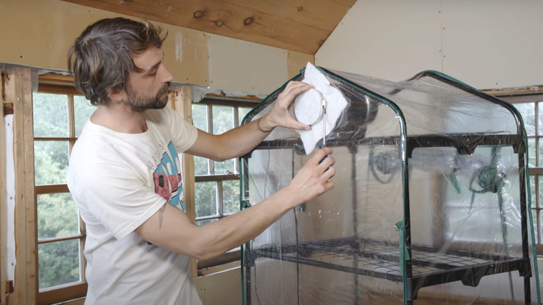 man setting up ventilation in mushroom greenhouse