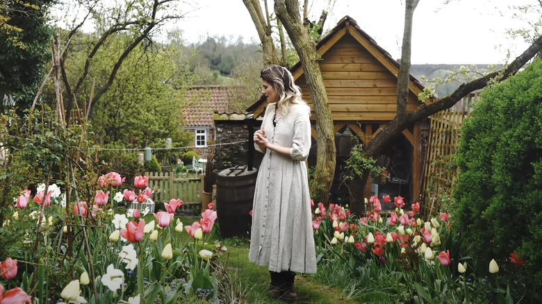 woman standing amidst blooming tulip garden