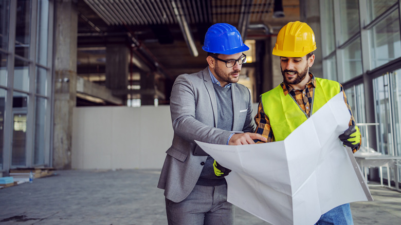 two men looking at plans 