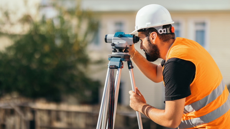 A person conducting a property line survey