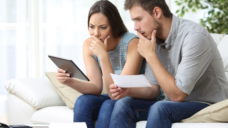 Confused looking couple on tablet