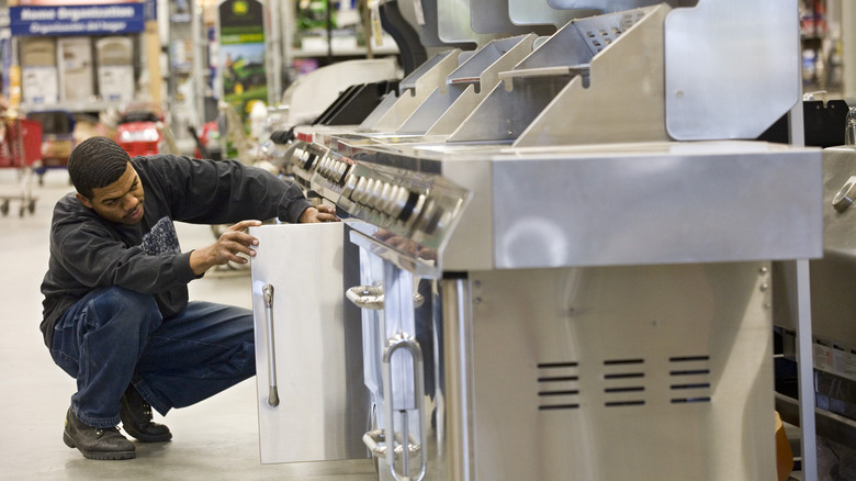 man inspecting grill at Lowe's