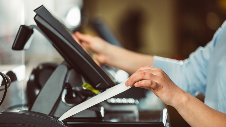 cashier pulling out receipt