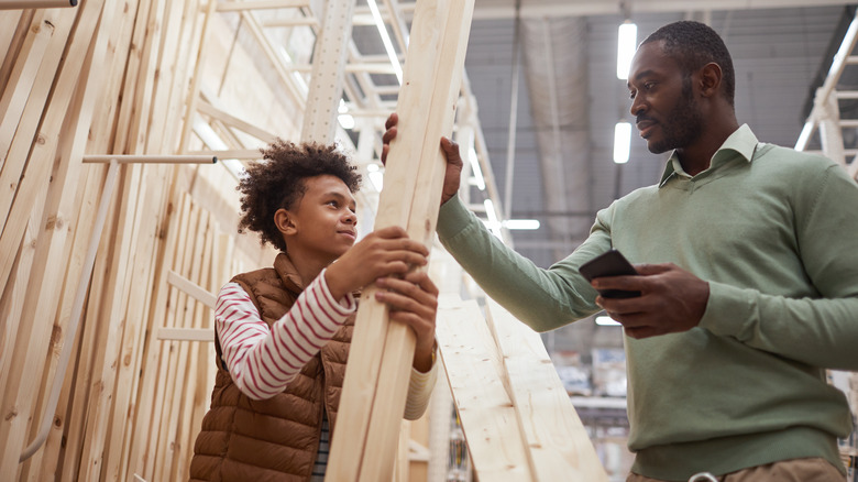 father and son holding lumber