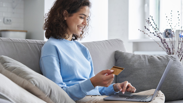 Woman with card on laptop