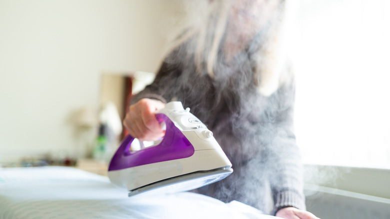 Woman ironing using steam 