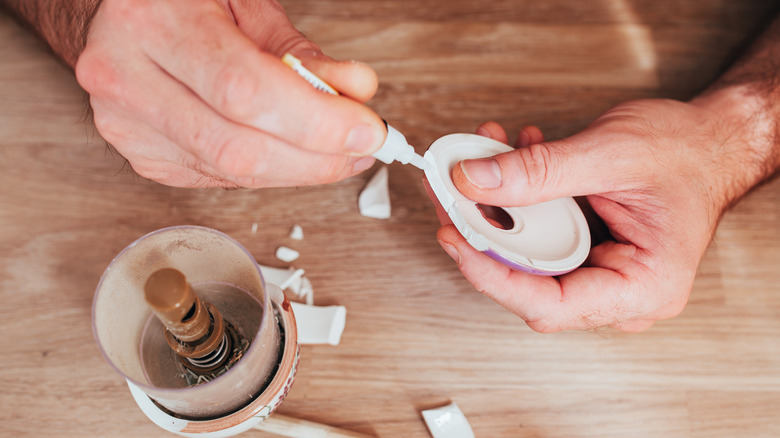 Person super gluing broken ceramics