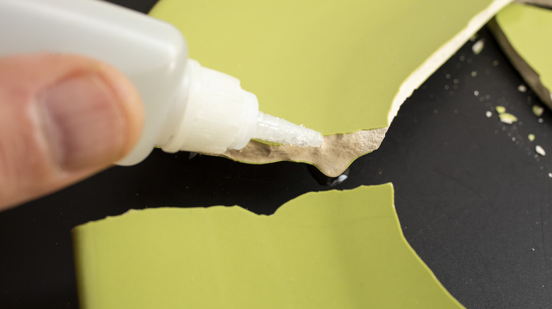 Persona squeezing glue onto a broken plate