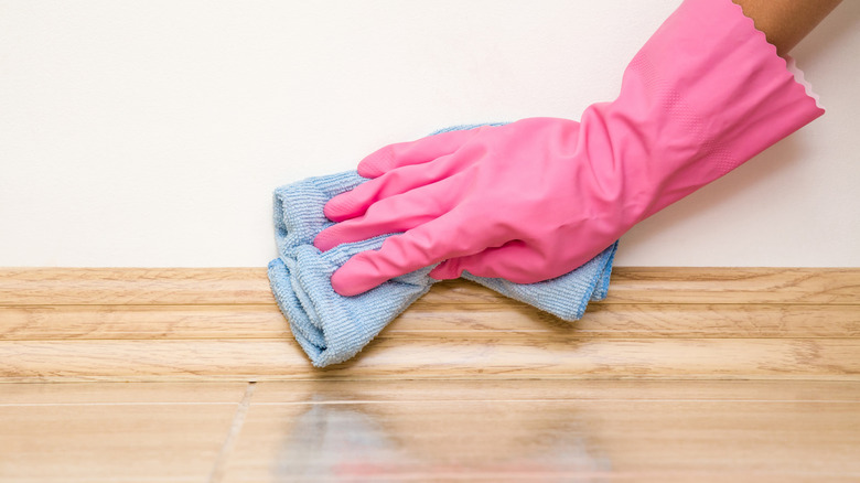 Cleaning baseboard with a microfiber cloth