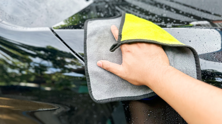 Using dual-sided microfiber cloth to clean car