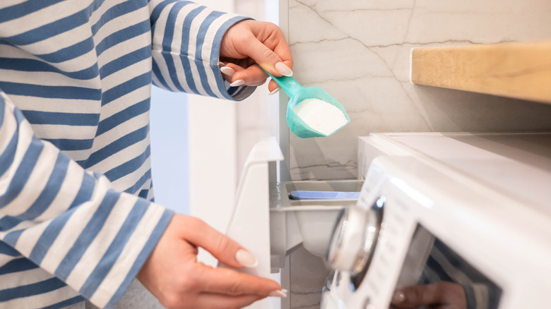 Adding powdered detergent to washing machine slot