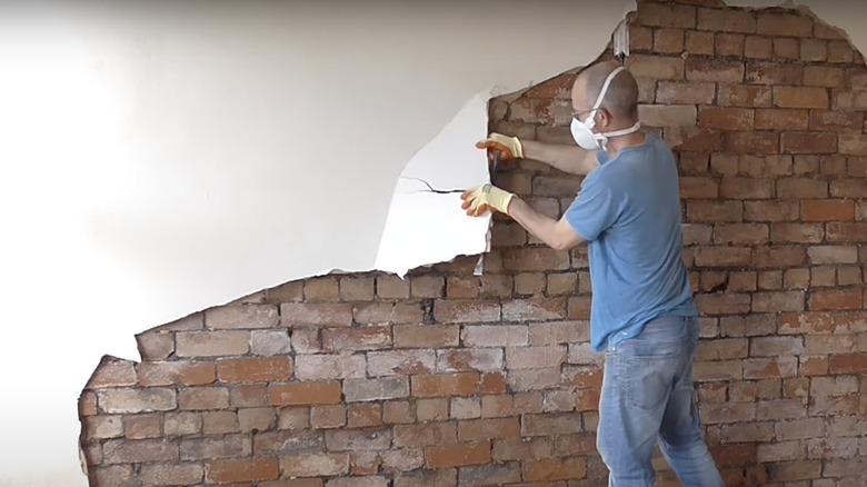 man in mask removing plaster