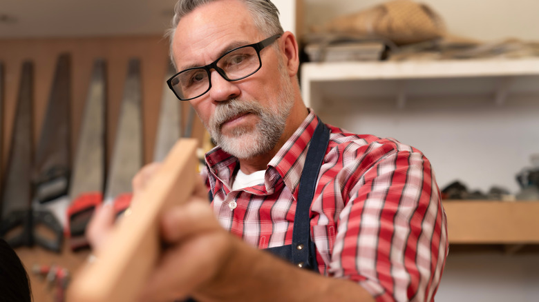 Wood worker looking at piece to prepare for work