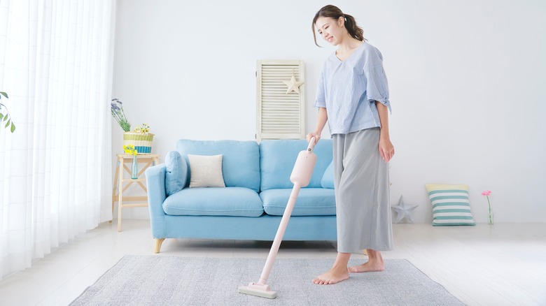 woman vacuuming area rug
