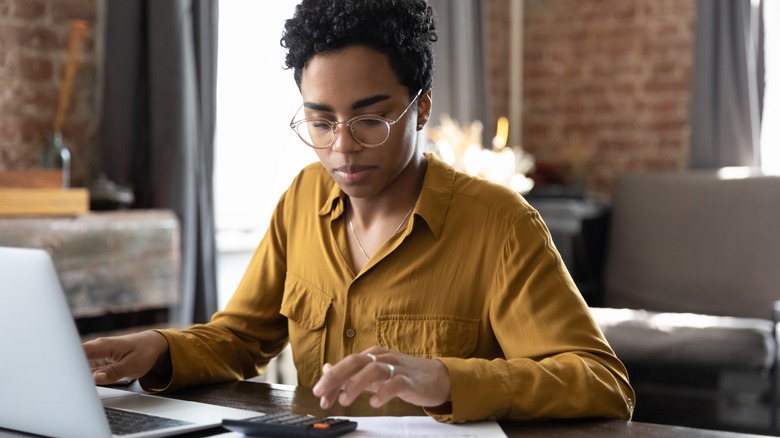 woman calculating budget on calculator