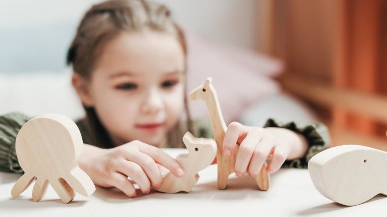 Girl playing on table with toys