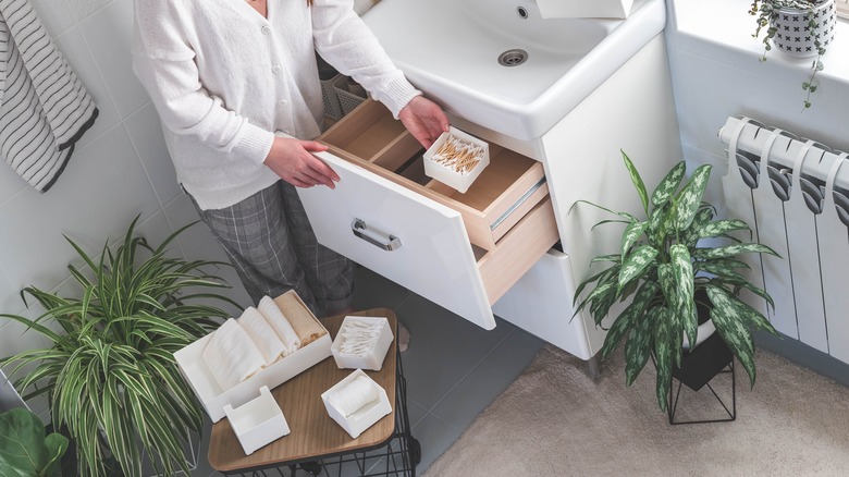 person organizing bathroom drawer