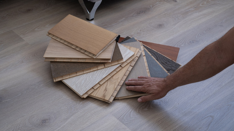 A person looking at various flooring shades