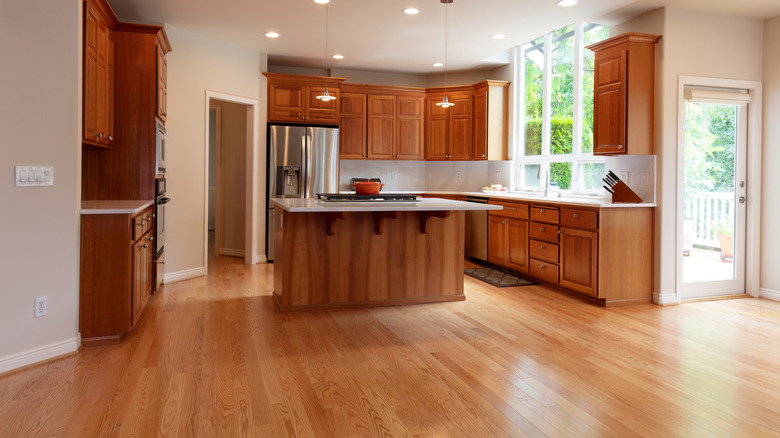 A kitchen with wood cabinets and hardwood floors