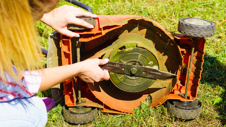 A person working on a mower blade