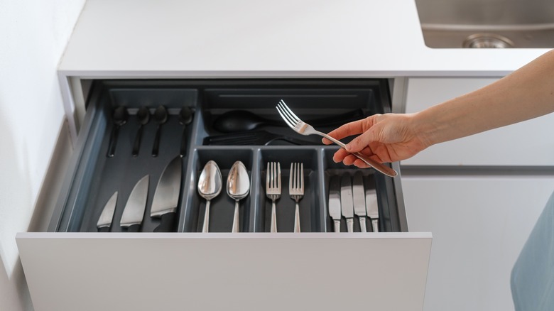 placing fork in organized drawer