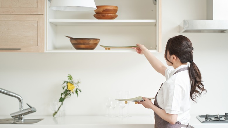 woman putting dishes away