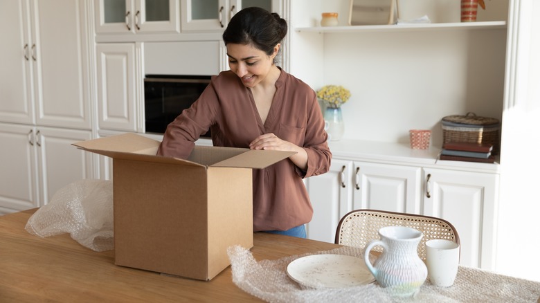 smiling woman unpacking dishes