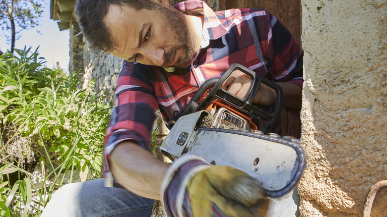 A man checks the sharpness of his chainsaw