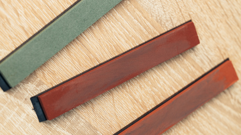 Three sharpening stones on wooden background