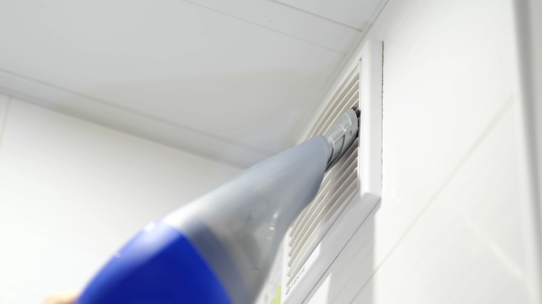 bathroom vent being vacuumed