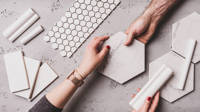 Two people comparing miter and bullnose tile options