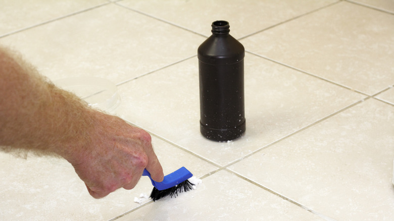 Man scrubbing grout