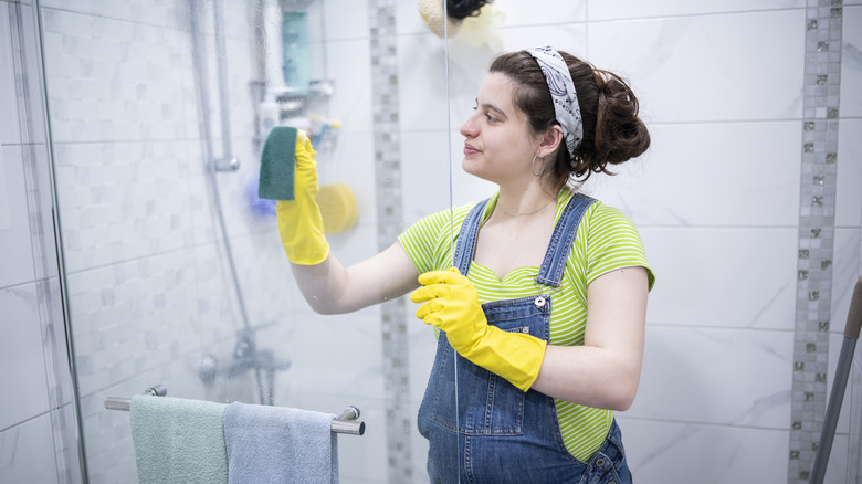 Woman cleaning shower door