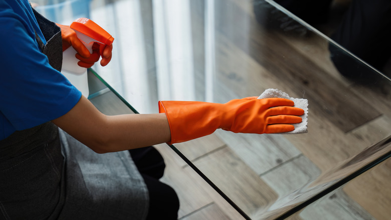 Person cleaning glass tabletop