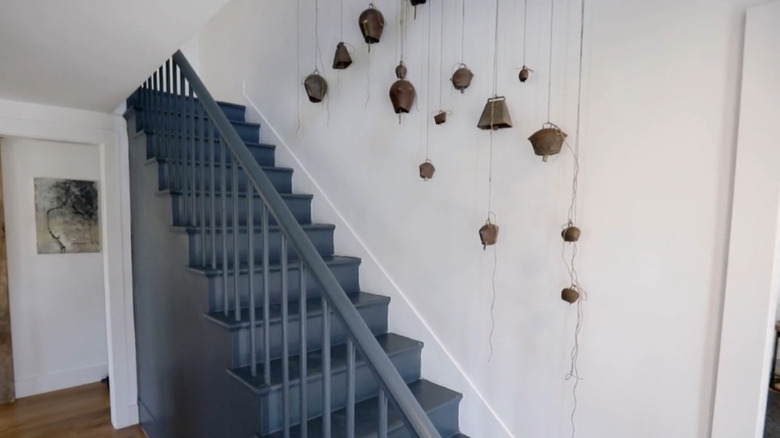 A group of cowbells hanging out stairway wall