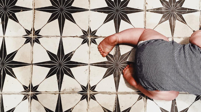 baby crawling on tiled floor