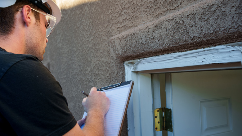 Man examining door jam