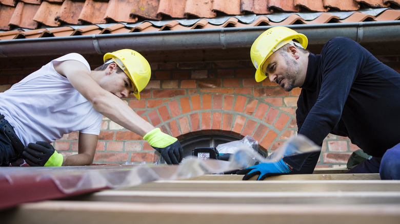 Two men installing metal roof
