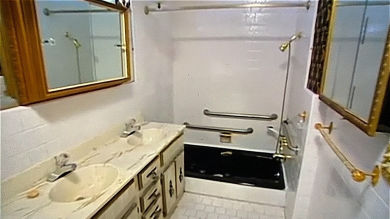 dated bathroom with black bathtub 