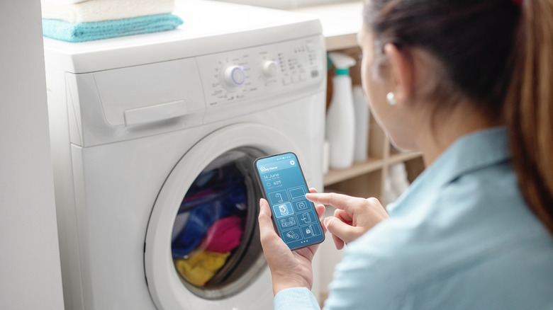 A woman using a smart washing machine