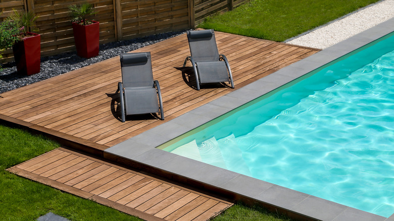 Lounge chairs on poolside deck