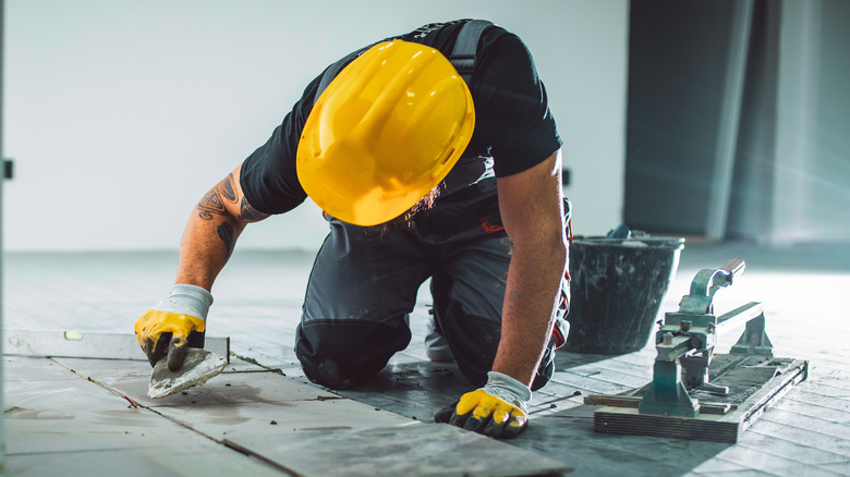 Man tiling a floor