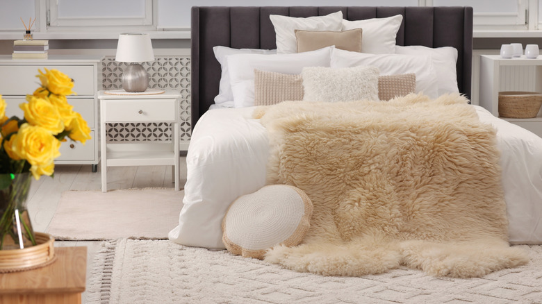 Bed with faux-fur throw and layers of throw pillows