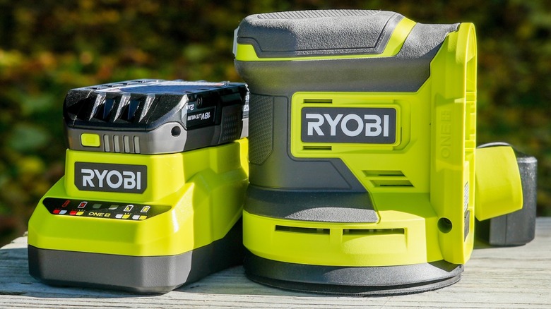 Ryobi device and battery charger on table outside