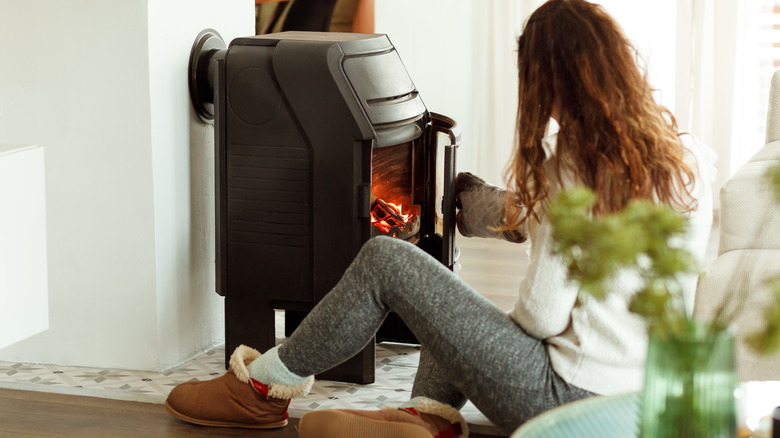 woman opening door of wood stove